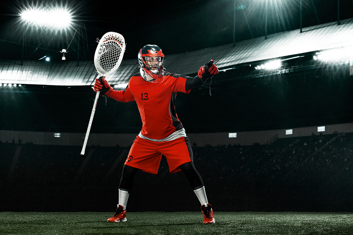 Lacrosse Player, athlete sportsman in red helmet on stadium background. Sport and motivation wallpaper.